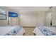 Bedroom with a large wardrobe, dresser with TV, and two beds with matching linens at 8735 Midnight Pass Rd # 105B, Sarasota, FL 34242