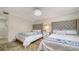 Charming bedroom featuring two beds with upholstered headboards, a chandelier and plenty of closet space at 8735 Midnight Pass Rd # 105B, Sarasota, FL 34242