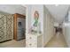 Inviting hallway featuring storage closets, a view of the kitchen, and tile floors at 8735 Midnight Pass Rd # 105B, Sarasota, FL 34242