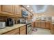 Kitchen featuring stainless steel appliances, granite countertops, wood cabinets and tiled floors at 8735 Midnight Pass Rd # 105B, Sarasota, FL 34242