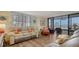 Inviting living room featuring sliding glass doors to the balcony and wood flooring at 8735 Midnight Pass Rd # 105B, Sarasota, FL 34242