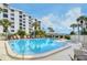 Large community pool and spa surrounded by lush landscaping and comfortable lounge chairs for relaxing and enjoying Florida at 8735 Midnight Pass Rd # 105B, Sarasota, FL 34242