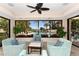 Comfortable sitting area with pool view from a wall of windows allows for serene relaxation in a verdant community at 8735 Midnight Pass Rd # 105B, Sarasota, FL 34242