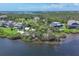 Expansive aerial view showcasing a waterfront community with lush greenery and serene water views at 92 Tidy Island Blvd, Bradenton, FL 34210