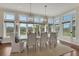 Light-filled dining room with large windows, elegant chandelier and seating for six at 92 Tidy Island Blvd, Bradenton, FL 34210