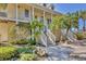 Charming home entrance with dual staircases, lush landscaping, and a stone bench at 92 Tidy Island Blvd, Bradenton, FL 34210