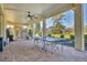 Covered patio area features brick flooring, ceiling fan, grill, and ping pong table at 92 Tidy Island Blvd, Bradenton, FL 34210