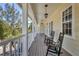 Relaxing porch area with rocking chairs, charming light fixtures, and beautiful natural surroundings at 92 Tidy Island Blvd, Bradenton, FL 34210