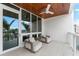A comfortable balcony has two lounge chairs, a ceiling fan and sliding glass doors at 1035 Seaside Dr # 308, Sarasota, FL 34242