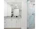 Elegant bathroom featuring a quartz countertop, framed mirror and marble tiled shower at 1035 Seaside Dr # 308, Sarasota, FL 34242
