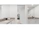 Bathroom featuring white cabinets, stone countertops, sinks, and a view of the bedroom through an open door at 1035 Seaside Dr # 308, Sarasota, FL 34242