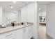 Bathroom featuring white cabinets, stone countertops, sinks, and a view of the bedroom at 1035 Seaside Dr # 308, Sarasota, FL 34242