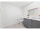 Bathroom featuring gray vanity with marble countertop, gray cabinetry and a decorative mirror at 1035 Seaside Dr # 308, Sarasota, FL 34242