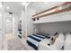 Bunk room with 4 twin beds with striped covers, wooden ladders, and overhead lighting at 1035 Seaside Dr # 308, Sarasota, FL 34242