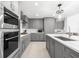 Modern kitchen with gray cabinets, quartz countertops, and stainless steel appliances at 1035 Seaside Dr # 308, Sarasota, FL 34242
