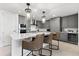 Modern kitchen features gray cabinets, stainless steel appliances, an island with marble countertops, and three bar stools at 1035 Seaside Dr # 308, Sarasota, FL 34242