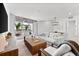 Bright living room features a large window, white furniture, a woven coffee table, and access to the dining area at 1035 Seaside Dr # 308, Sarasota, FL 34242
