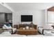 Inviting living room with neutral tones, a woven coffee table, comfortable seating, and a view into the modern kitchen at 1035 Seaside Dr # 308, Sarasota, FL 34242