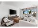Bright living room with white furniture, a woven coffee table, and a large window overlooking palm trees at 1035 Seaside Dr # 308, Sarasota, FL 34242