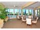 Comfortable lounge area in the clubhouse with seating, palm trees and pool views at Beachplace at 1055 Gulf Of Mexico Dr # 405, Longboat Key, FL 34228