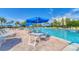 Inviting community pool featuring lounge chairs and tables with umbrellas for residents to relax at Beachplace at 1055 Gulf Of Mexico Dr # 405, Longboat Key, FL 34228