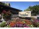 Well-maintained Beachplace community signage with lush landscaping, and buildings in the background under a sunny sky at 1055 Gulf Of Mexico Dr # 405, Longboat Key, FL 34228