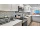 Bright kitchen featuring white cabinetry, stainless steel appliances, and a view to the ocean at 1055 Gulf Of Mexico Dr # 405, Longboat Key, FL 34228