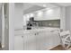 Kitchen with white cabinets, stainless appliances, and marble countertops at 1055 Gulf Of Mexico Dr # 405, Longboat Key, FL 34228