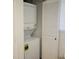 Laundry closet with stacked washer and dryer and white louvered doors at 1055 Gulf Of Mexico Dr # 405, Longboat Key, FL 34228