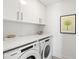 Well-lit laundry room with white cabinets and counter space and front load appliances at 111 S Pineapple Ave # 1014, Sarasota, FL 34236