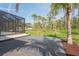 View of the back of the home with a screened-in pool and expansive lush green backyard at 115 Solana St, North Port, FL 34287