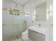 Modern bathroom featuring glass shower with gold fixtures and sleek vanity at 115 Solana St, North Port, FL 34287