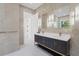Modern bathroom featuring dual sinks with marble countertops, dark cabinetry, and sleek tiled walls at 115 Solana St, North Port, FL 34287
