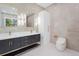 Elegant bathroom featuring dual sinks with marble countertops, modern fixtures, cabinetry and sleek marble tiled walls at 115 Solana St, North Port, FL 34287