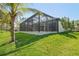 Beautiful backyard featuring a screened in pool area and lush lawn at 115 Solana St, North Port, FL 34287