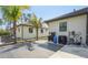 View of the back of the home with tile patio, surrounded by well-maintained landscaping and palm trees at 115 Solana St, North Port, FL 34287