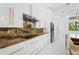 Modern kitchen featuring white cabinets, gold hardware, and elegant granite countertops at 115 Solana St, North Port, FL 34287