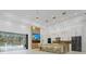 Open living space with a large island, TV, and access to an outdoor pool at 115 Solana St, North Port, FL 34287