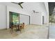 Inviting outdoor patio with a dining set, sliding glass doors, and travertine flooring for relaxing and entertaining at 115 Solana St, North Port, FL 34287