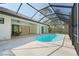 Screened-in pool area with a water feature, travertine tile, and access to the home's outdoor patio and living spaces at 115 Solana St, North Port, FL 34287