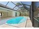 Beautiful pool with a screen enclosure, water features, and a spacious patio, offering a private outdoor oasis at 115 Solana St, North Port, FL 34287