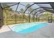 Enclosed pool area with waterfall features and a spacious patio, providing a private and relaxing outdoor space at 115 Solana St, North Port, FL 34287