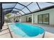 Large pool with a screened-in enclosure, waterfall features, and access to the home's outdoor patio and yard at 115 Solana St, North Port, FL 34287