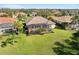 Aerial view of the home featuring a large screened in lanai, luscious lawn, and manicured landscaping at 12736 Penguin Dr, Bradenton, FL 34212