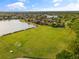 An aerial view of a vast, well-maintained community athletic field near a serene lake and residential homes at 12736 Penguin Dr, Bradenton, FL 34212