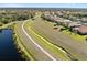Aerial view of a long green space with a side walk for walking, close to neighborhood homes and a pond at 12736 Penguin Dr, Bradenton, FL 34212
