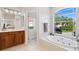Bright bathroom with garden tub under a large window with views of lush landscaping at 12736 Penguin Dr, Bradenton, FL 34212