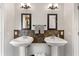 Bathroom featuring dual pedestal sinks, elegant mirrors and fixtures at 12736 Penguin Dr, Bradenton, FL 34212