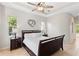 Bright bedroom featuring neutral walls, tile flooring, and tray ceiling with ceiling fan at 12736 Penguin Dr, Bradenton, FL 34212