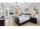 Bright bedroom featuring neutral walls, tile flooring, and tray ceiling with ceiling fan at 12736 Penguin Dr, Bradenton, FL 34212